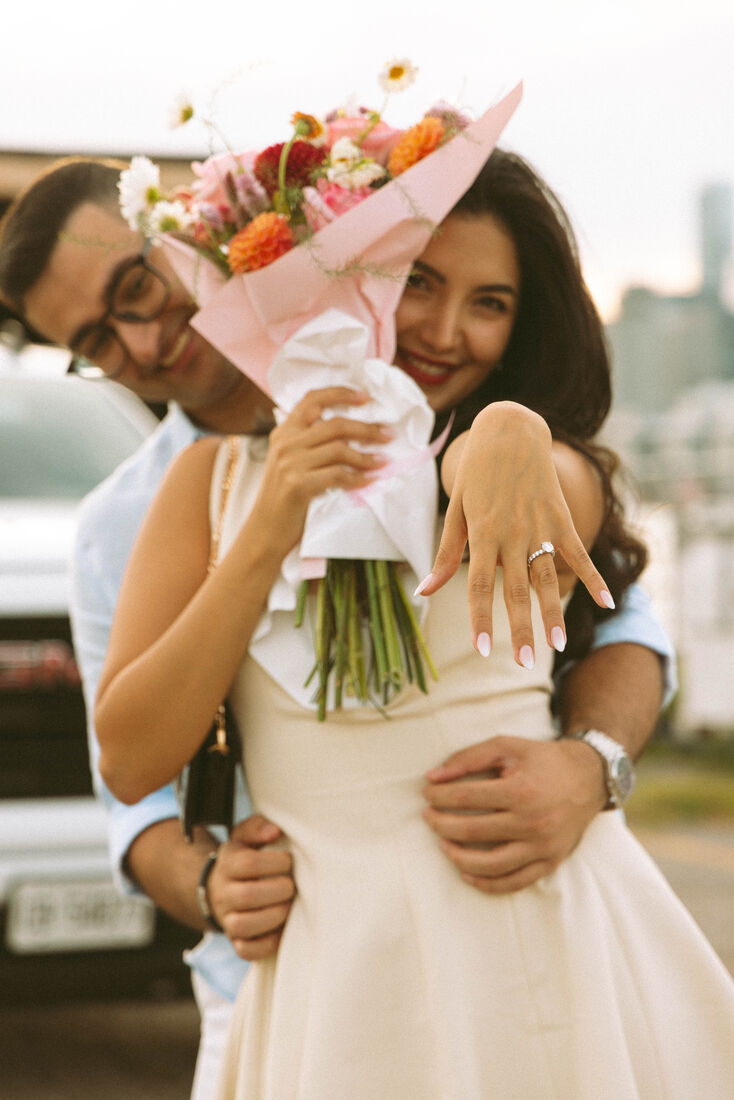 Mehrnaz showing her ring in Majid's arms, holding a bouquet